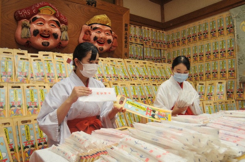 千歳あめの袋詰め作業をする巫女=兵庫県西宮市の西宮神社で2021年10月8日午前11時23分、花牟礼紀仁撮影
