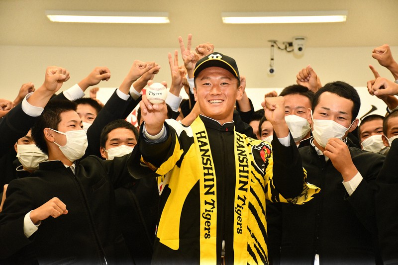 阪神からドラフト1位で指名され、仲間らと記念撮影に臨む高知の森木大智投手(中央)=高知市の高知学園大で2021年10月11日午後5時50分、小宅洋介撮影