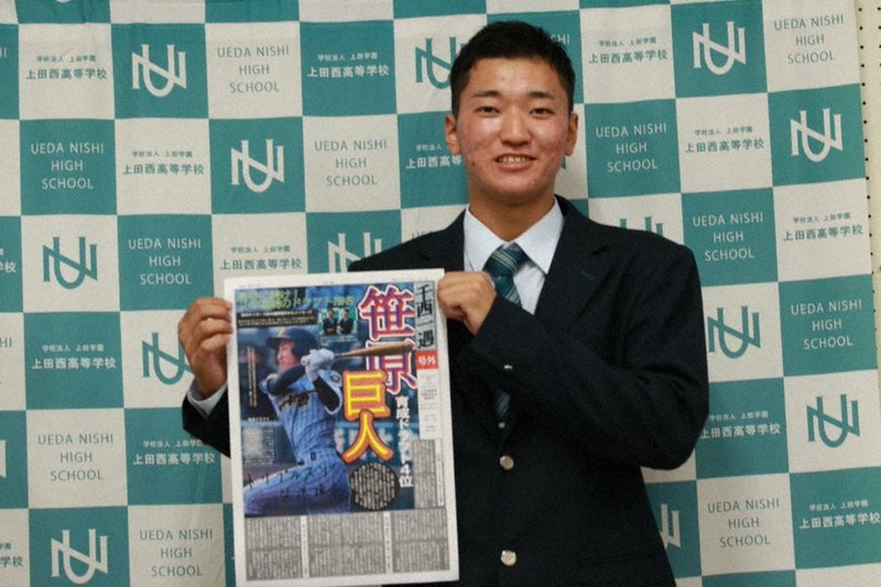 上田西高校新聞委員会が制作した号外を持ち笑顔を見せる同校3年の笹原操希=2021年10月11日(同委員会提供)