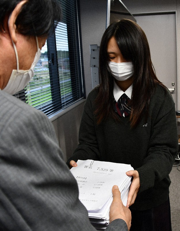 岡本栄市長(手前)に20歳成人式を求める署名簿を手渡す高校生=三重県伊賀市役所で、大西康裕撮影