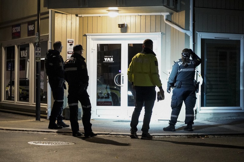 矢が刺さった壁周辺を調べる警察官ら=ノルウェー南部コングスベルグで2021年10月13日、AP