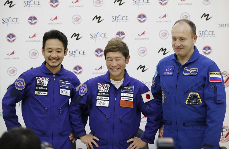 報道陣に宇宙飛行への意気込みを語る前沢友作さん(中央)=モスクワ郊外のガガーリン宇宙飛行士訓練センターで2021年10月14日、AP