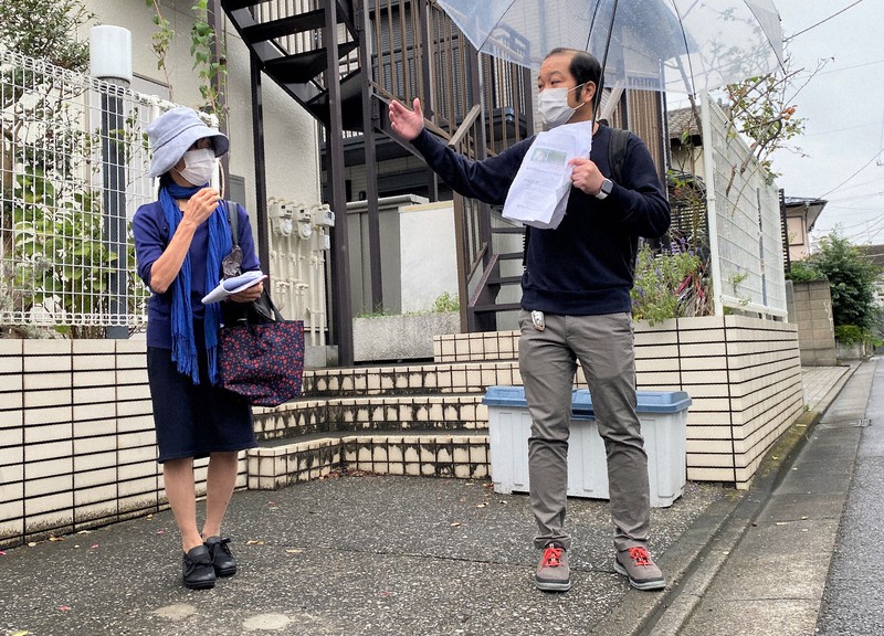 河村晴子さん(左)の自宅前で、地盤調査の結果を説明する稲積真哉教授=東京都調布市で2021年10月13日午後2時3分、島袋太輔撮影