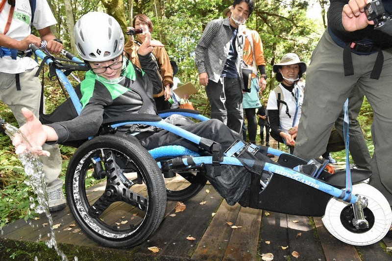 たじま高原植物園の湧き水を楽しむ小林快多さん(手前)と見守る衣川勝海さん(後方中央)=兵庫県香美町村岡区で2021年10月11日午前10時58分、浜本年弘撮影