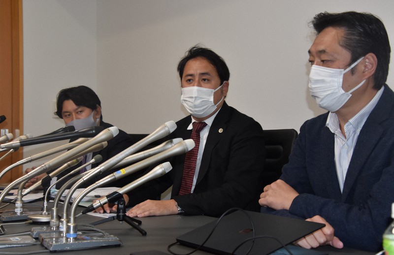 記者会見に臨む「熱海市盛り土流出事故被害者の会」会長の瀬下雄史さん(右)と加藤博太郎弁護団長(中央)ら=東京都港区で2021年10月18日午後5時20分、深野麟之介撮影