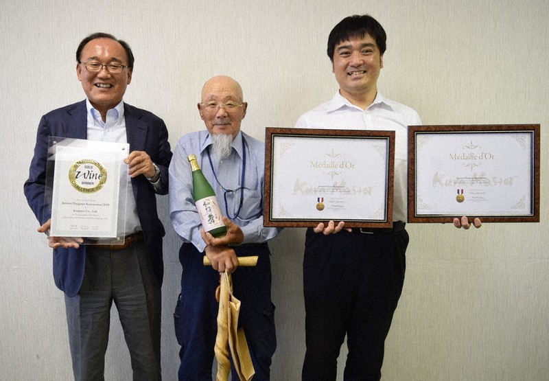 賞状を手にほほ笑む(左から)吉村修二さん、篠塚敏雄さん、小森順一さん。酒瓶は純米吟醸の「加須の舞」=埼玉県加須市役所で2021年10月7日、隈元浩彦撮影