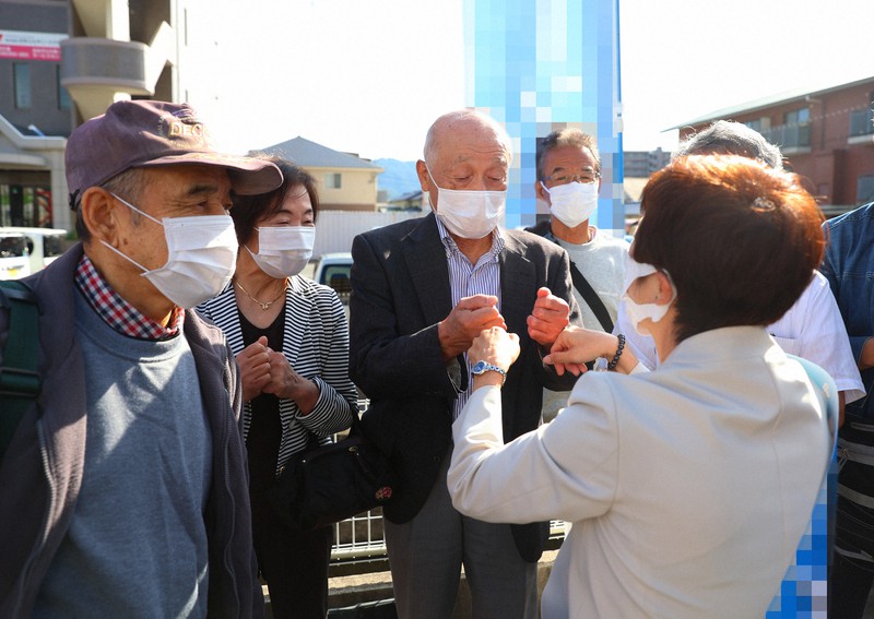 候補者とグータッチする有権者ら=広島市安佐南区で2021年10月19日午前9時37分、猪飼健史撮影(画像の一部を加工しています)