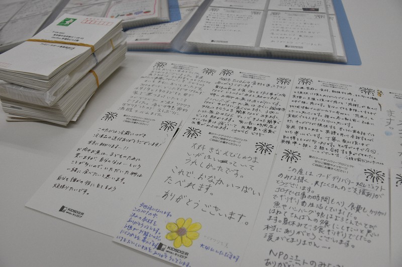 NPO法人キッズドアから食料品の無償提供を受けた親子から届いたはがき。「これで、おなかいっぱいたべれます」「冷蔵庫の中が空になってゆく不安をぬぐいさってくれた」と厳しい暮らしぶりが記されていた=東京都中央区で2021年10月12日、原田啓之撮影