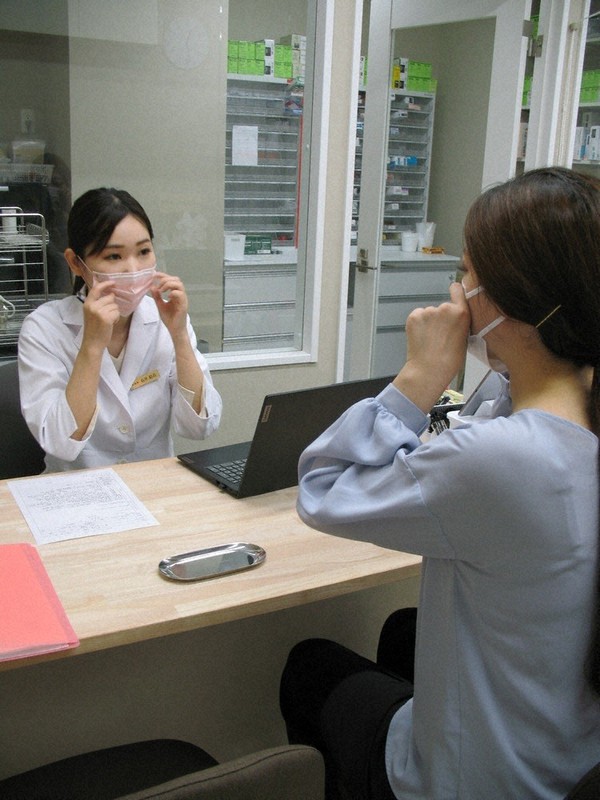 薬剤師として顧客のカウンセリングに応じるアリス薬局の石井結衣社長(左)=大阪市北区曽根崎新地1で、長崎薫撮影