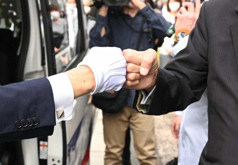 衆議院議員選挙の出陣式で、新型コロナウイルス感染症予防のため支援者とグータッチをする候補者(左)=京都市下京区で2021年10月19日、山崎一輝撮影