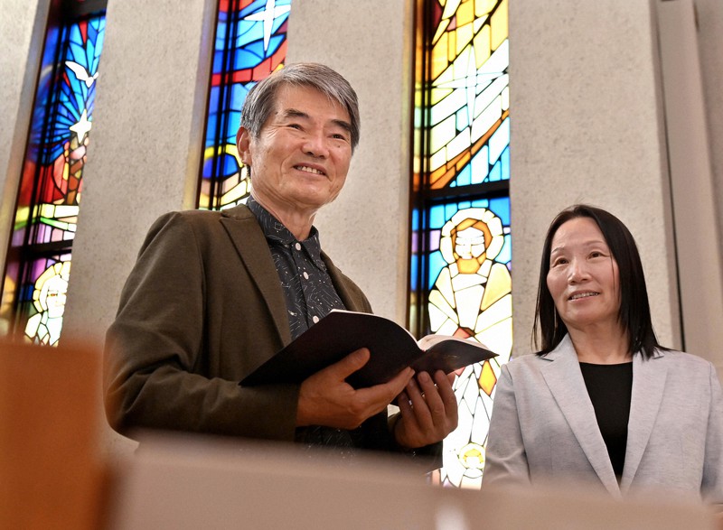 地元のカトリック教会で韓国語によるミサに参列する李哲さん、閔香淑さん夫妻。「ここに来ると穏やかな気持ちになり、心が落ち着きます」と語った=大阪市内で2021年10月17日、山田尚弘撮影