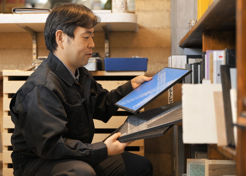 さまざまな仕上がり見本を手にする原田左官工業所の原田宗亮社長=東京都文京区で、手塚耕一郎撮影