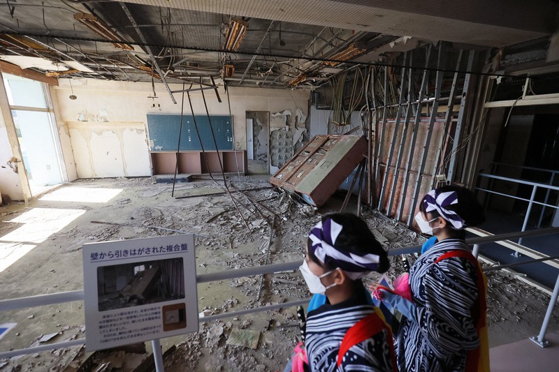 震災遺構「浪江町立請戸小学校」の開館記念式典で「請戸の田植踊」を披露した後、校内を見て回る踊り手たち=2021年10月24日午後0時11分、和田大典撮影