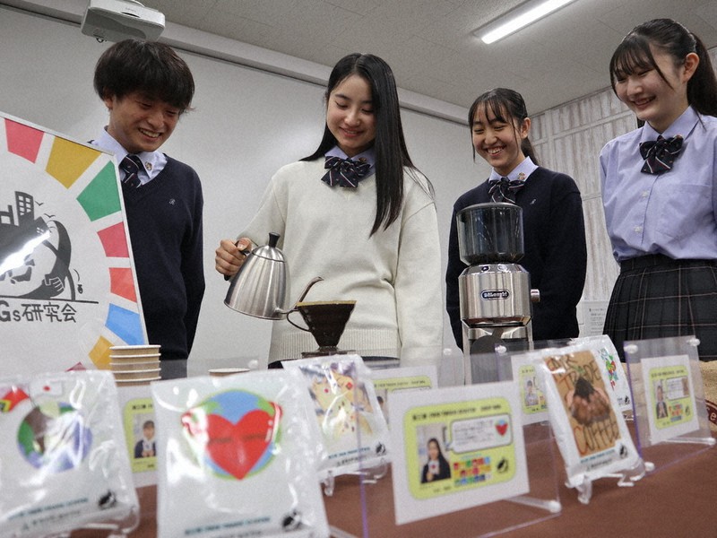 フェアトレードコーヒーの入れ方を実演するSDGs研究会の部員たち。ドリップバッグのパッケージは生徒のデザイン