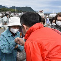 街頭演説後、集まった支援者らと「グータッチ」をする候補者＝三重県内で、谷口豪撮影