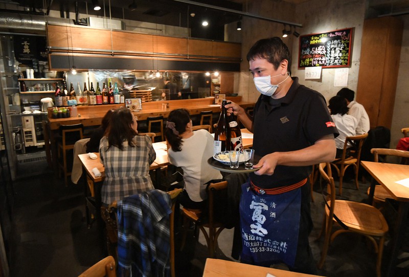 通常営業再開を迎え、接客のため店内を動き回る居酒屋「にほんしゅ ほたる」店長の山畑晃一さん=東京都千代田区で2021年10月25日午後6時24分、宮間俊樹撮影