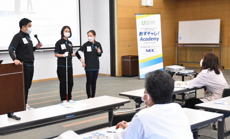 白杖(はくじょう)を持った視覚障害者への接し方を説明する田中さん(左)と日本財団スタッフ=香川県丸亀市保健福祉センターで、川原聖史撮影
