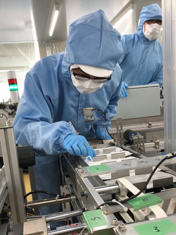 医療品メーカー・スズラン本社の製造ラインで不織布マスクを確認する従業員=名古屋市北区で2021年10月12日、高本耕太撮影