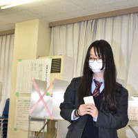 臨時期日前投票所で投票に臨む大友美咲さん＝茨城県稲敷市江戸崎甲の県立江戸崎総合高校で2021年10月25日、庭木茂視撮影