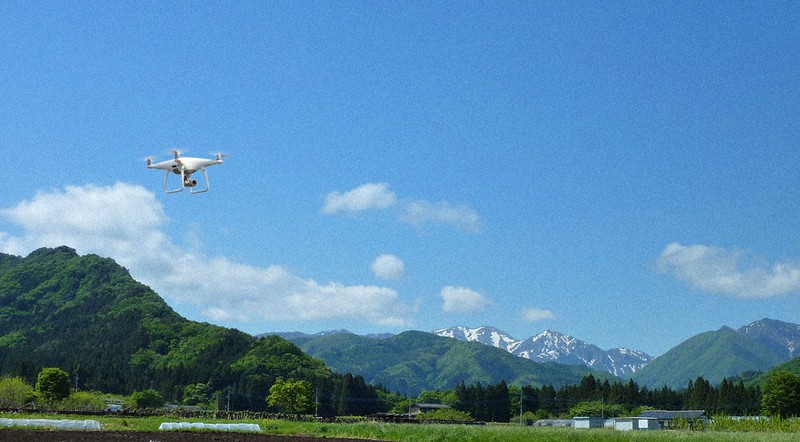 群馬県みなかみ町の山あいを飛ぶドローン=楽天グループ提供