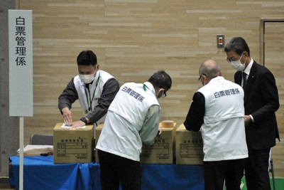 甲賀市議選で市選管委員長（右端）の確認を受けながら、未使用の票を封印する白票管理係＝甲賀市水口町鹿深の水口体育館で2021年10月17日午後9時9分、村瀬優子撮影