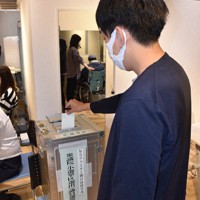 商業施設に設けられた期日前投票所で1票を投じる若者＝奈良市で2021年10月27日午後3時2分、吉川雄飛撮影