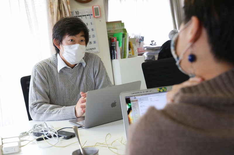 ボランティアの若者と打ち合わせをするNPO法人「POSSE」スタッフの岩橋誠さん（左）＝東京都世田谷区で2021年10月27日、長谷川直亮撮影