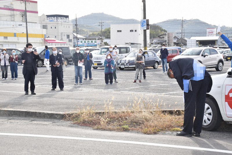 深々と頭を下げ、支持を訴える候補者(右)=岡山市内で2021年10月30日午後3時13分、戸田紗友莉撮影(画像の一部を加工しています)