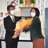当選確実となり支援者から花束を受け取る田嶋要氏（左）＝千葉市中央区で2021年10月31日午後9時10分、柴田智弘撮影