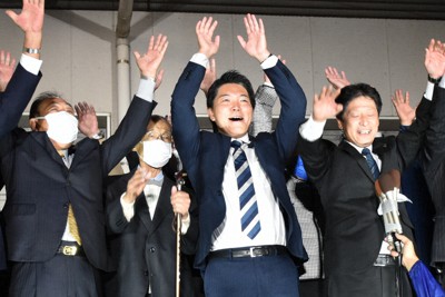 熊本2区で当選確実の報を受け、万歳する西野太亮氏（中央）＝熊本市南区で2021年10月31日午後8時38分、栗栖由喜撮影
