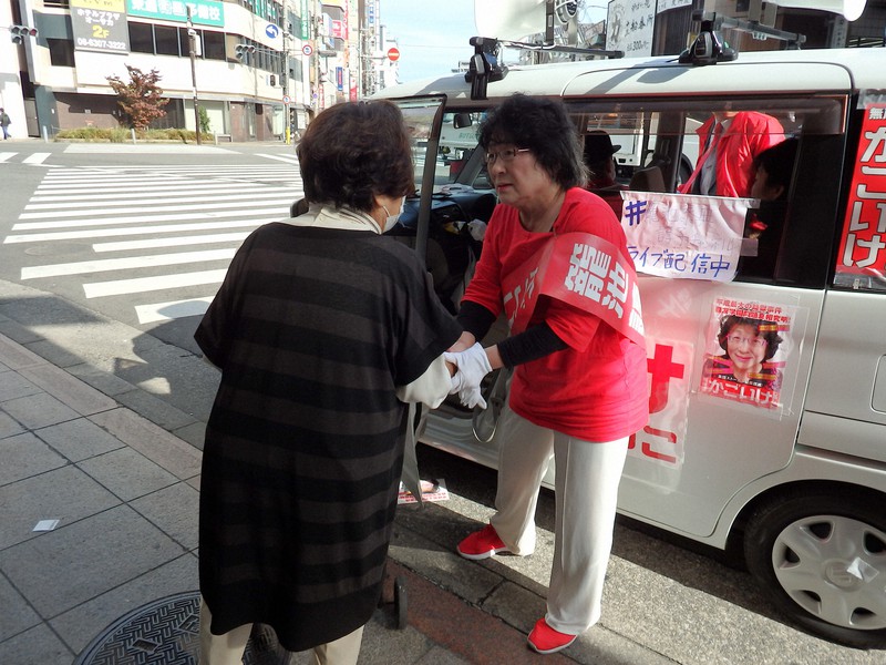 通行人から話し掛けられ、車を降りて握手する籠池諄子さん=大阪市淀川区の阪急十三駅前で2021年10月27日、山本直撮影