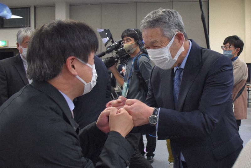支持者とグータッチをする佐藤勉氏=栃木県小山市立木で2021年10月31日午後11時47分、鴨田玲奈撮影