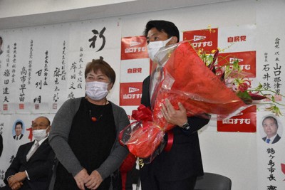 選対関係者から花束を受け取る山口晋氏（右端）＝埼玉県坂戸市で2021年10月31日午後11時31分、平本絢子撮影