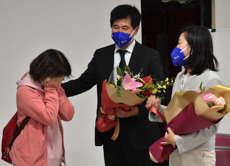 当選時のために用意した花束を渡した後、涙を流す支持者の肩に手をそえる今井雅人氏(中央)。右は妻恵子さん=岐阜県可児市下恵土で2021年11月1日午前0時21分、荒川基従撮影
