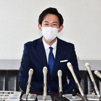 衆院選の結果を伝える朝刊各紙を前に初当選について語る川崎秀人氏＝三重県鈴鹿市算所町の事務所で、大西康裕撮影