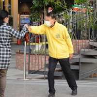 街頭に立ち、市民とグータッチを交わす岸本氏＝和歌山市の南海和歌山市駅前で、山口智撮影