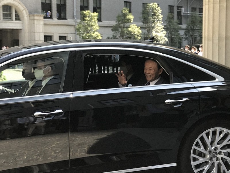 職員から大きな拍手を受けて車に乗り込み、財務省を後にする麻生太郎前財務相=東京都千代田区の財務省で2021年10月5日、町野幸撮影