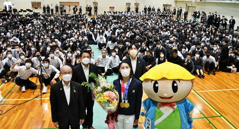 母校の生徒らとともに記念撮影に臨む大橋悠依選手(手前中央)=草津市渋川2の草津東高で2021年10月18日午前11時1分、礒野健一撮影