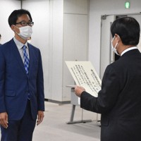 県選管の立石健二委員長（右）から当選証書を受け取る小山展弘氏＝静岡市葵区の県庁で2021年11月2日、金子昇太撮影
