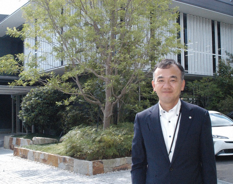 緑豊かな岐阜造園本社前に立つ常務取締役の小栗栄一さん=岐阜市で2021年9月28日、浜名晋一撮影