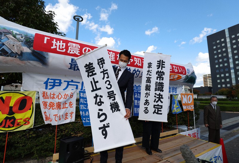 伊方原発3号機の運転差し止めを認めない決定が出され、垂れ幕を掲げる原告団=広島市中区で2021年11月4日午後2時3分、猪飼健史撮影