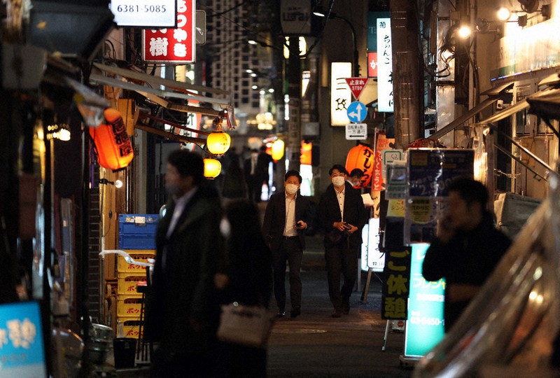 飲食店の通常営業が可能となり、ネオンが灯る飲食店街を歩く人たち=東京都港区で2021年10月25日、小川昌宏撮影