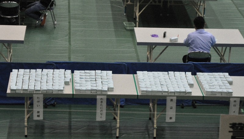 宮崎1区の開票結果確定予定時刻(午前1時)の35分前になっても、分類などを終えて集票台に積まれているのは、投票総数の約6割に過ぎなかった=宮崎市の市総合体育館で2021年11月1日午前0時25分、杣谷健太撮影