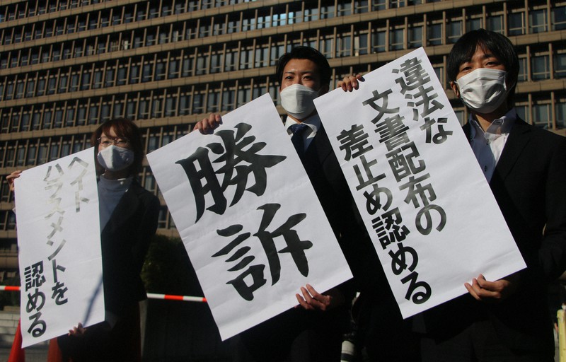 大阪高裁の判決後に「勝訴」などと書かれた紙を掲げる原告側=大阪市北区で2021年11月18日午後2時11分、榊原愛実撮影