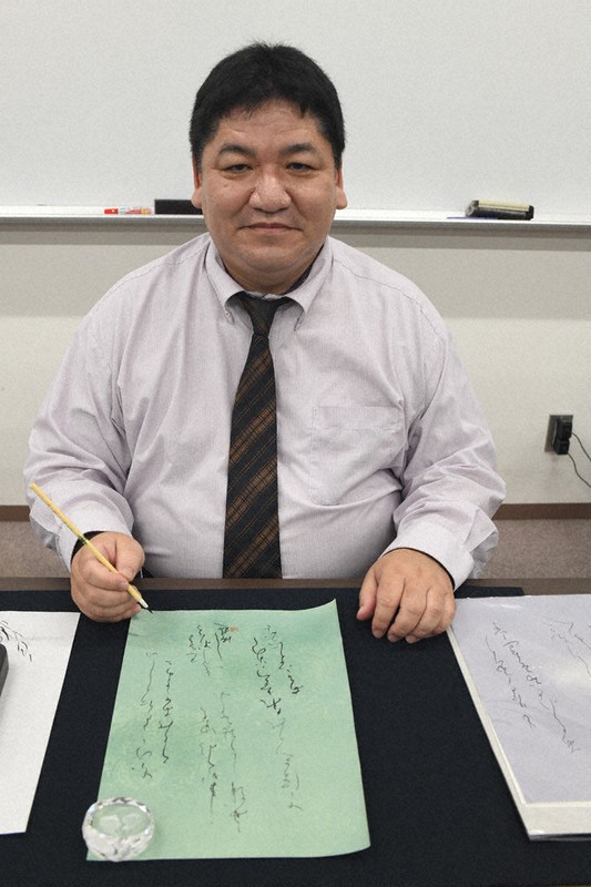 愛用の筆を握る駒林燈舟さん=2021年11月18日、仲村隆撮影