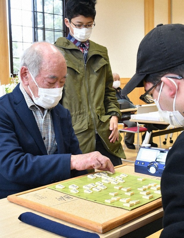 「盤寿」を控え対局に臨むアマ五段の津崎澄男さん(左)=兵庫県豊岡市の県立但馬文教府で2021年11月21日午前10時25分、浜本年弘撮影