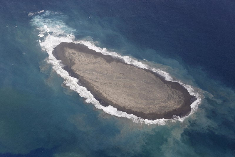 波に浸食される福徳岡ノ場の新島=東京・小笠原諸島で2021年11月25日午後0時45分、本社機「希望」から