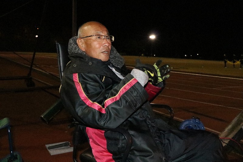 日が落ちてからも練習を見守る東邦銀行陸上競技部の川本和久監督=福島市で2021年11月18日午後5時47分、高橋秀明撮影