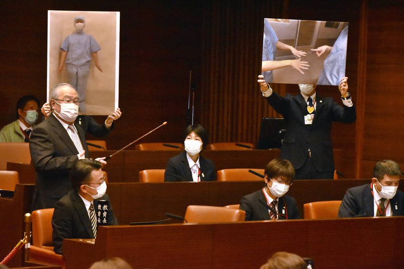 市議会全員協議会で調理場の異物混入対策を説明する、都城学校給食センターの受託業者(左)ら=宮崎県都城市の都城市議会で2021年11月25日午後1時16分、成松秋穂撮影