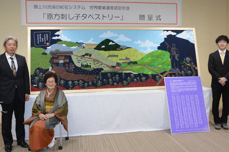 贈呈したタペストリーを紹介する遠藤きよ子さん(左から2人目)ら=山形県米沢市役所で2021年11月19日、佐藤良一撮影